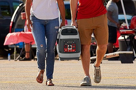 Two people carrying a generator 