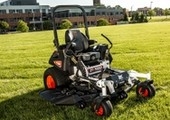 Stationary mower with property in background