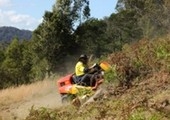 Male riding mower on slope