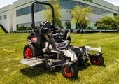 Stationary mower with building in background