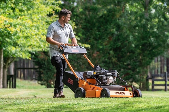 Man with commercial walk behind mower